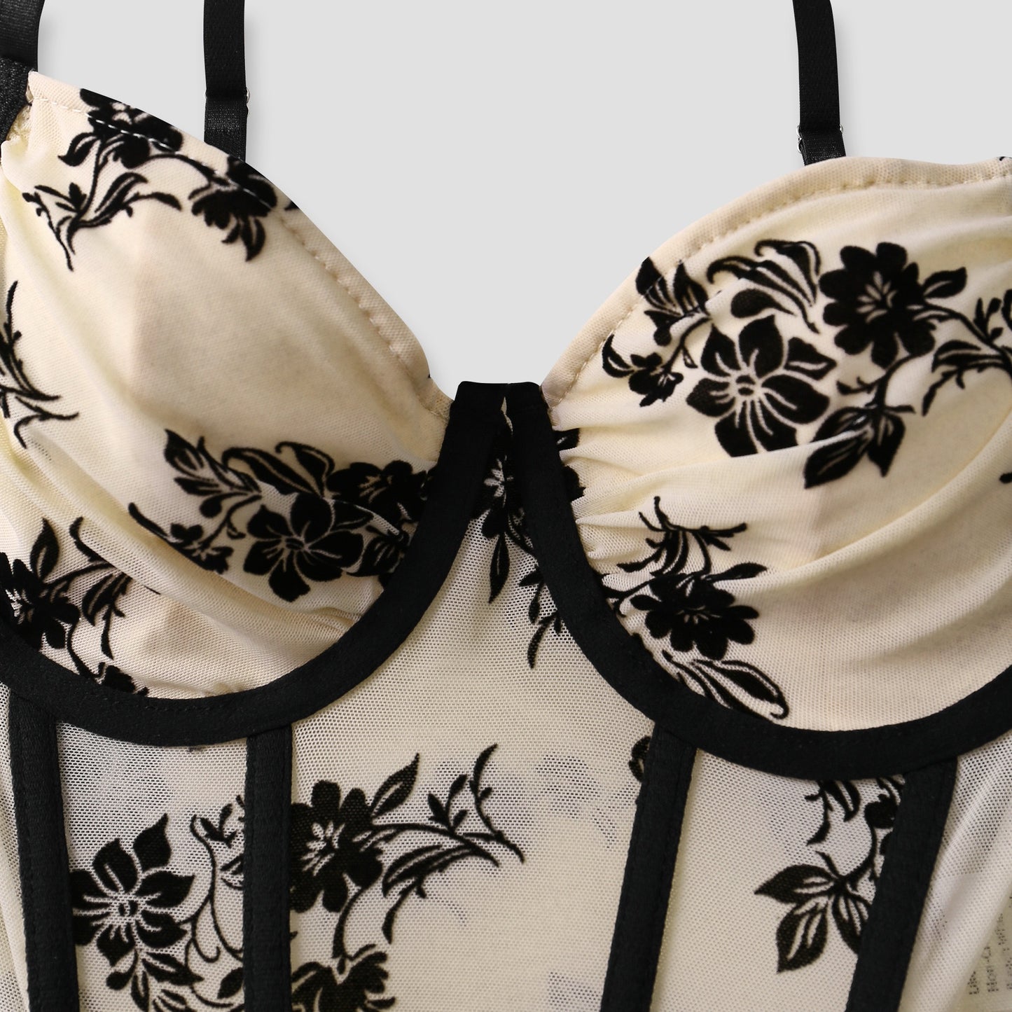 Close-up of sculpted bust cups and floral embroidery on mesh corset