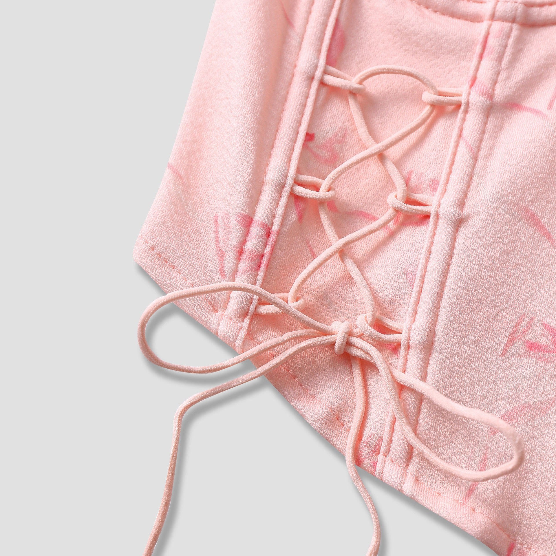 Close-up of bust seam structure and bow print on pink corset top
