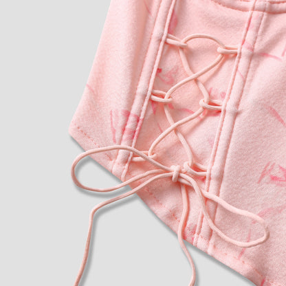 Close-up of bust seam structure and bow print on pink corset top