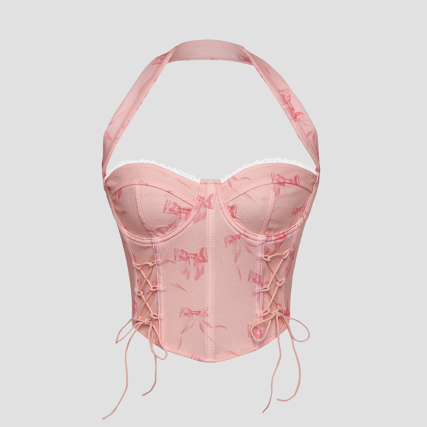 Model wearing pink bow print lace-up corset top with halter neck – front view