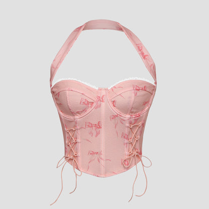 Model wearing pink bow print lace-up corset top with halter neck – front view
