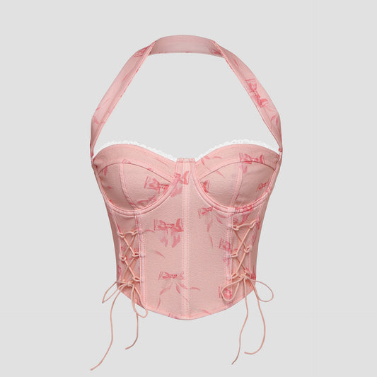 Model wearing pink bow print lace-up corset top with halter neck – front view